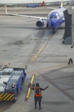 Phoenix, Arizona - A ground crew worker directs a Southwest Airlines jet as it arrives at Sky