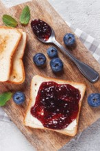 Toast with blueberry jam, on a wooden chopping board, breakfast, homemade, no people