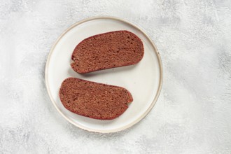 Delicious slices of homemade dark bread on a simple ceramic plate in a kitchen setting