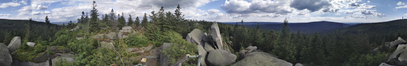Panoramic view of a mountain landscape with rocks and trees under a dramatic sky, Franconian