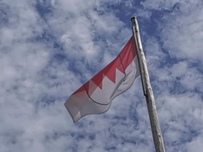 Franconian flag, red and white flag blowing in the wind against a slightly cloudy sky, Upper