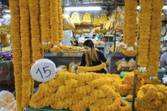 Bangkok, Thailand. March 2rd 2025. A Thai woman making traditional flower garlands at Pak khlong