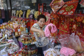 Bangkok, Thailand. February 18th 2025. A woman selling Chinese souvenirs and gifts from a street