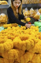 Bangkok, Thailand. March 2rd 2025. A Thai woman making traditional flower garlands at Pak khlong