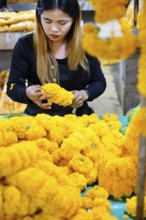 Bangkok, Thailand. March 4th 2025. A Thai woman making traditional flower garlands at Pak khlong