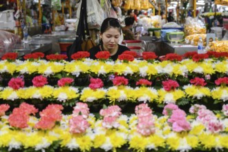 Bangkok, Thailand. March 2rd 2025. A Thai woman at a stall selling traditional flower arrangements