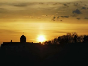 Silhouette of Rosenberg Fortress in Kronach in front of dramatic sunset sky, Frankenwald nature