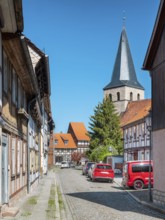 Street with half-timbered houses and cobblestones, in the back the church of St. Nikolai,