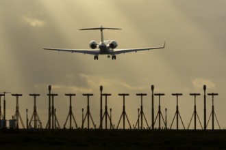 Executive business jet aircraft in flight on approach to land at sunset at London Stansted airport,