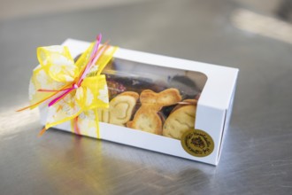 Gift box filled with Easter cookies, decorated with a yellow ribbon, Easter production of regional