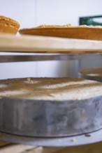 Large cakes prepared on wooden shelves in a bakery, Easter production of regional products,