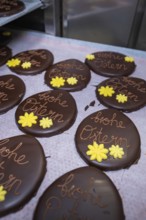 Chocolate Easter eggs decorated with yellow flowers, served on a tray, Easter production of