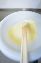 White chocolate on a spoon in liquid state, Easter production of regional products, Haselstaller