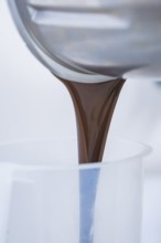 Liquid chocolate is poured into a container, Vegan Tart Production, Haselstaller Hof, Gechingen,