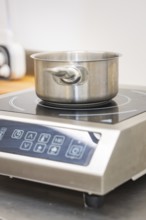 Stainless steel pot on an inductive hotplate in the kitchen, vegan cake production, Haselstaller