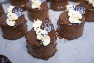 Close-up of chocolate tarts with cream and café logo, vegan cake production, Haselstaller Hof,