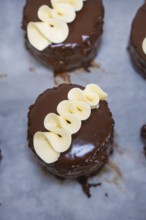 Small round chocolate cakes decorated with white chocolate, vegan cake production, Haselstaller