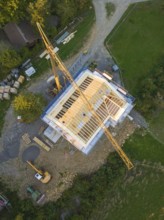 Aerial view of a construction site with crane and semi-finished building in rural area, timber