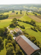 Panoramic view of landscape with fields and small construction site next to a solar building,
