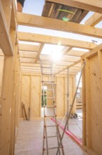 Interior of a wooden building panel with sun rays through ceiling opening, timber house building,