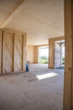 Interior view of a wooden building under construction with large amounts of light, timber house