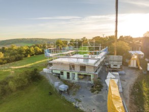 Building construction in a natural environment with crane and scaffolding, timber house