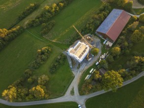 Aerial view of a construction site with a building under construction and solar roof in green
