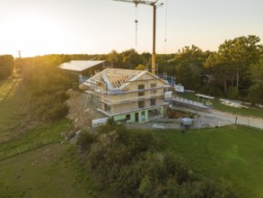 Building under construction at sunset, surrounded by nature in a rural location, timber house