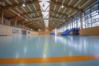 Modern sports hall with wooden roof, bright floor and large climbing frame, Schlehengäu sports hall