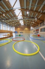 Colourful rings and balls on the floor in a large, well-lit sports hall, Schlehengäu Sporthalle