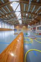 Tires lie on the floor of a gym next to a long wooden bench, Schlehengäu Sporthalle Gechingen, Calw