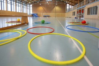 Various tires and balls on the floor of a light-flooded gym, Schlehengäu Sporthalle Gechingen, Calw