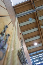 Climbing rope attached to a sports hall with wooden walls and neon lights, Schlehengäu Sporthalle