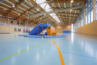 Empty sports hall with equipment available and a window front that illuminates the room,