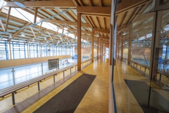 Long corridor in a gymnasium with large glass front and wooden architecture, Schlehengäu Sporthalle