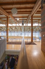 Extensive hall with wooden structure and windows across the entire wall height that let in plenty