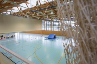 View of a playing field in a sports hall with nets in the foreground, Schlehengäu Sporthalle