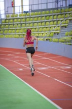 Female athlete concentrated while running, career lines in focus, middle distance runner Katharina