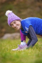 Woman wearing colorful winter clothes smiling in a meadow, relaxed and joyful atmosphere, middle
