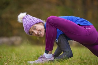 Woman wearing colorful clothes doing relaxation exercises in nature, smiling and showing joy,