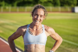 Sportswoman with happy expression on the track after training, radiates satisfaction, middle