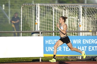 Woman running fast and dynamically on a sports track, middle distance runner Katharina Jaiser,