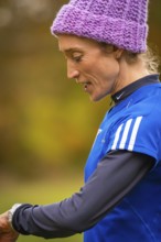 Close-up of a woman wearing sporty clothes, in an autumn setting, middle distance runner Katharina