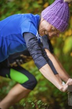 Close-up of a woman doing outdoor training in autumn, wearing sportswear and smiling, middle