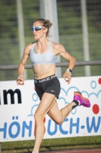 Focus on a sprinting athlete in sporty clothes in sunny weather, middle distance runner Katharina