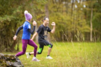 Two people running through an autumnal landscape, middle distance runner Katharina Jaiser,