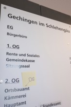 Guide in the building shows various offices and floors, bright room with lettering, Gechingen Town