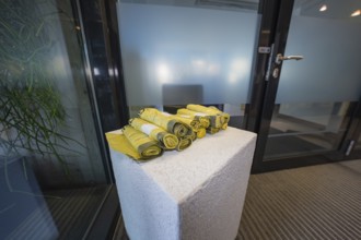 Yellow rolled up fabrics on a concrete pedestal in an office environment, Gechingen Town Hall, Calw
