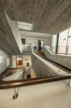 Modern staircase with concrete walls and wooden details, open architecture, interior view,