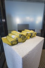 Yellow rolled up fabrics on a concrete base in a simple setting, Gechingen Town Hall, Calw